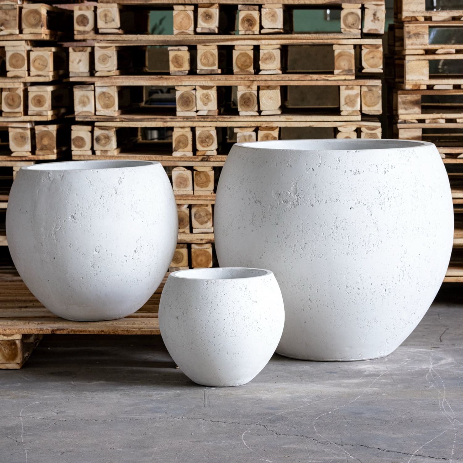 Three white, round, textured planters.