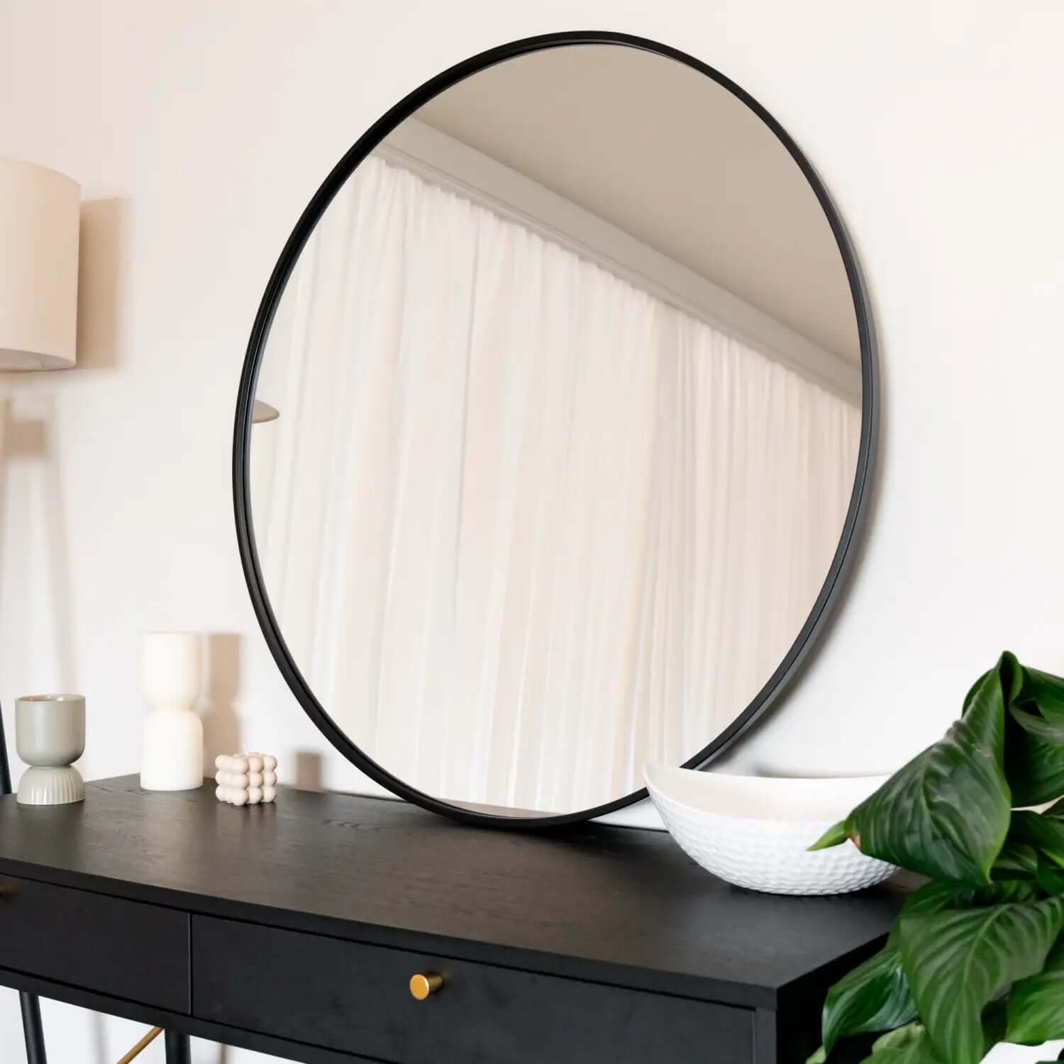 Round mirror with a thin black frame.