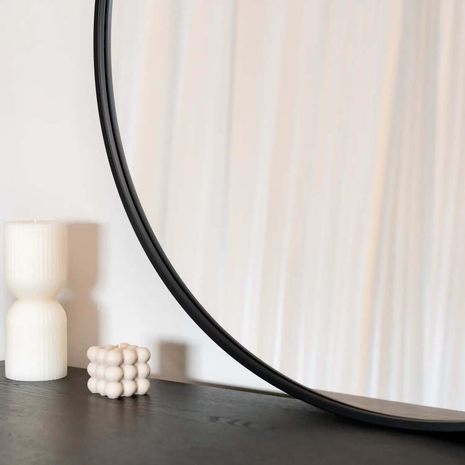 Round mirror with a black metal frame.