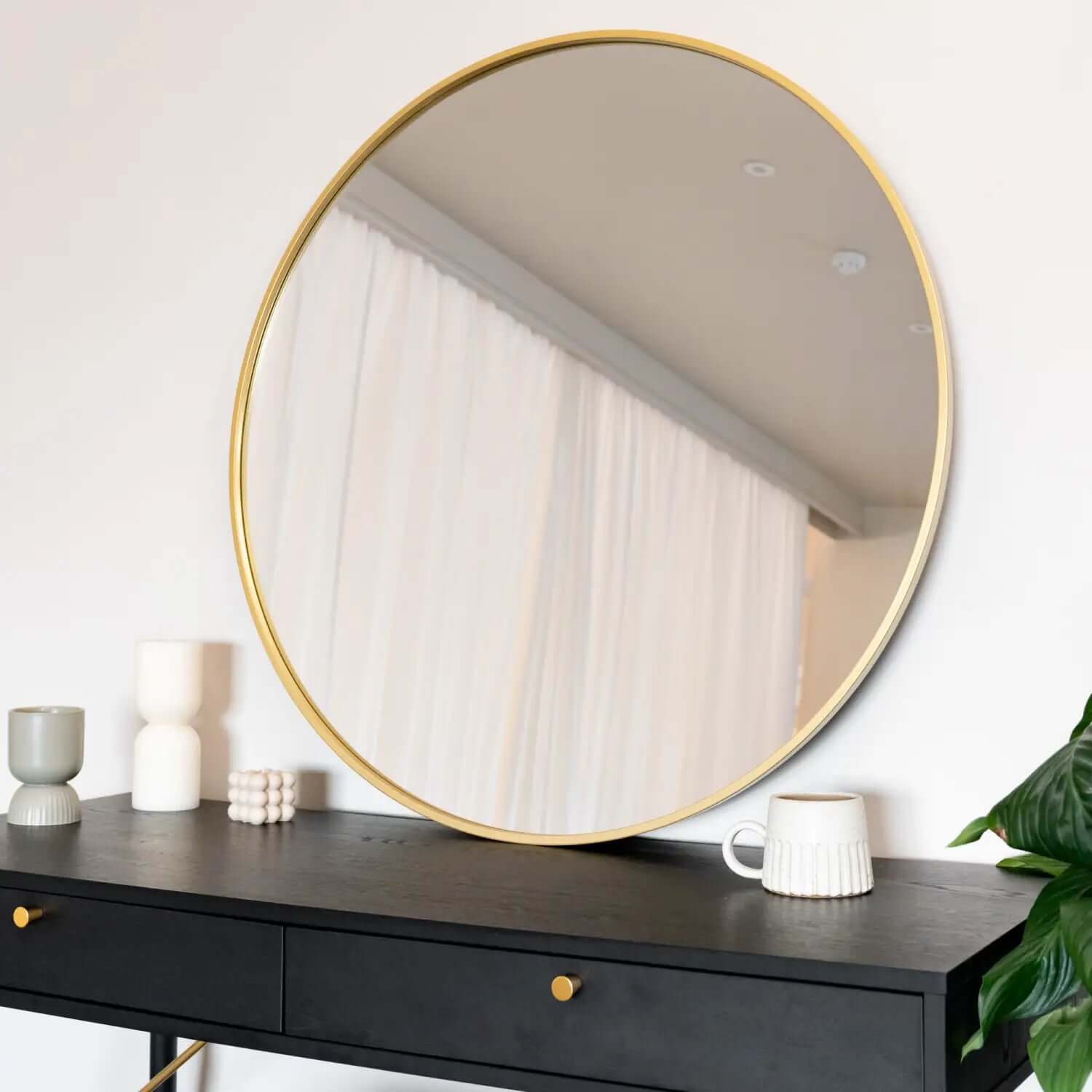 Round mirror with a thin gold frame.