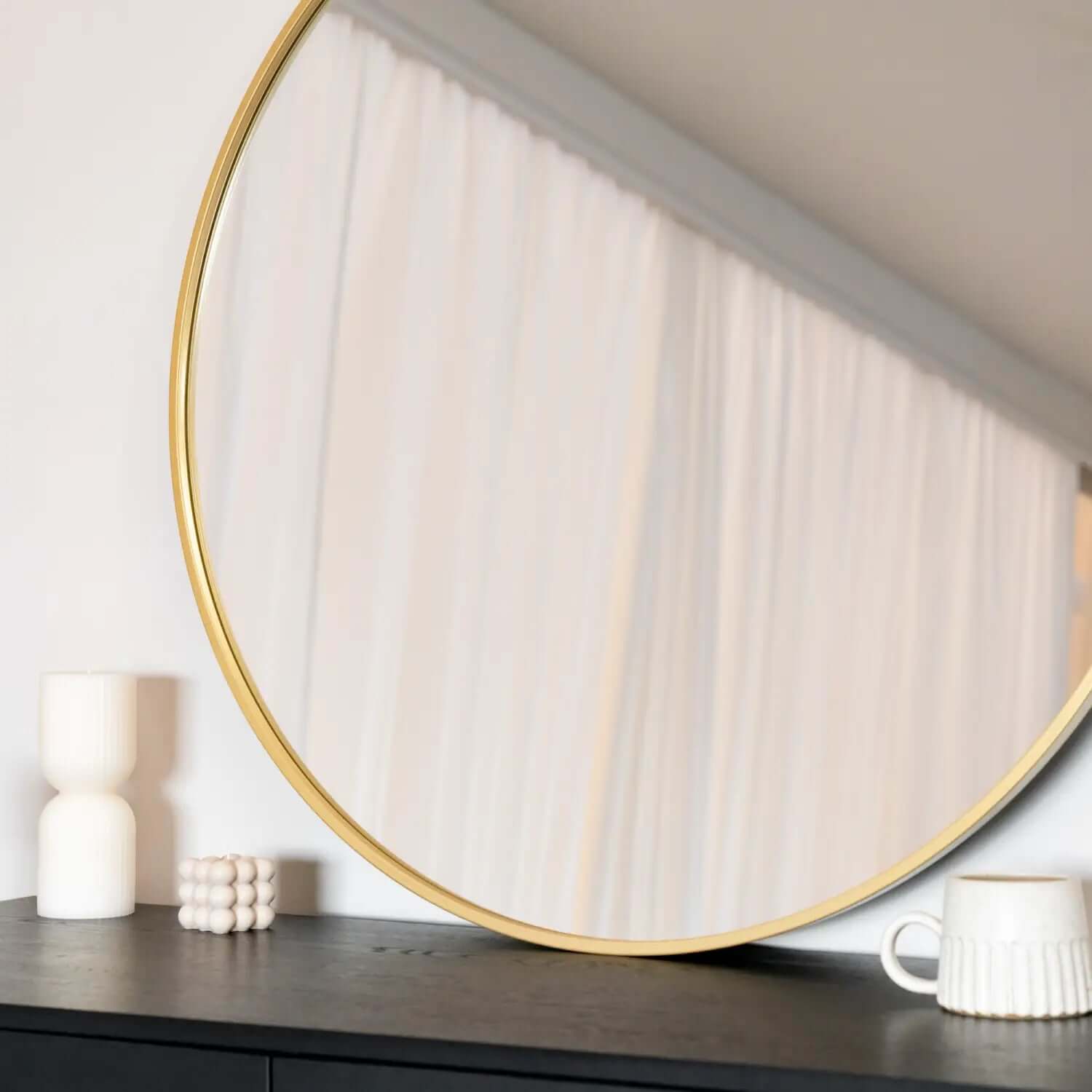 Round mirror with a gold frame.