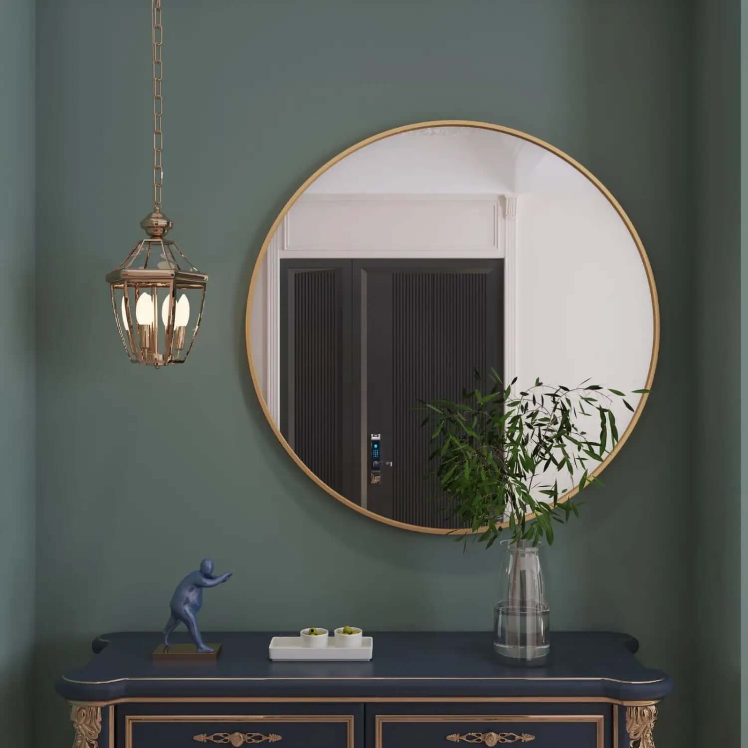 Circular gold-framed mirror mounted on a sage green wall.