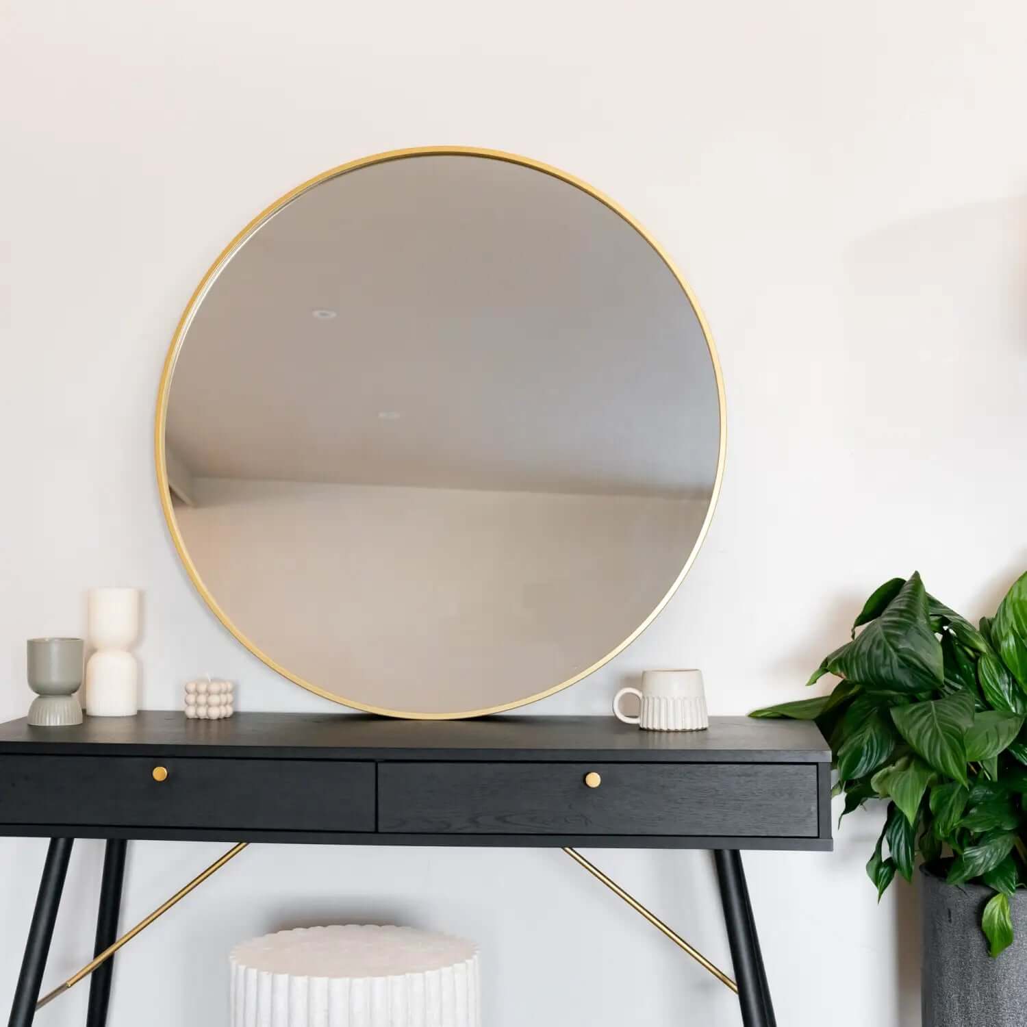 Circular gold-framed mirror with a clean, modern design.