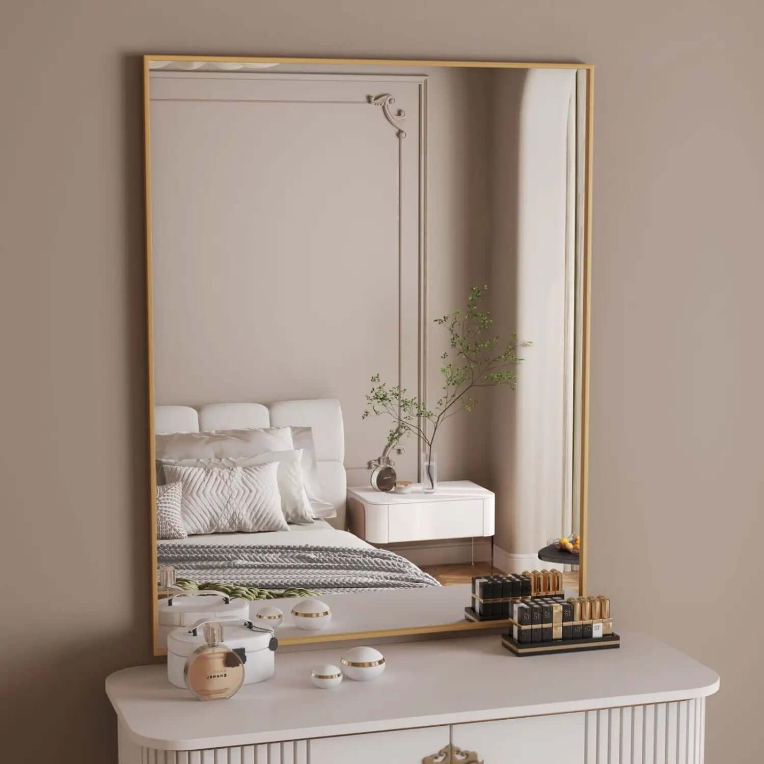 Gold-framed rectangular mirror mounted above a white dresser.