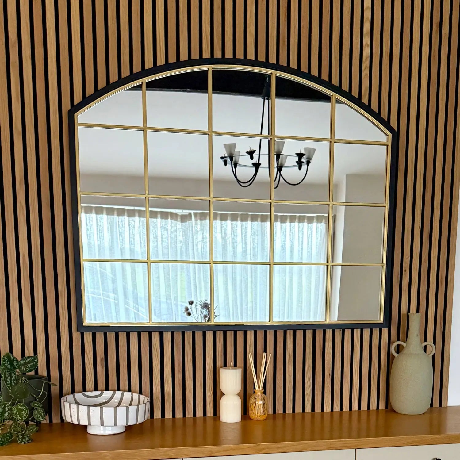 Arched window-style mirror with gold grid pattern.