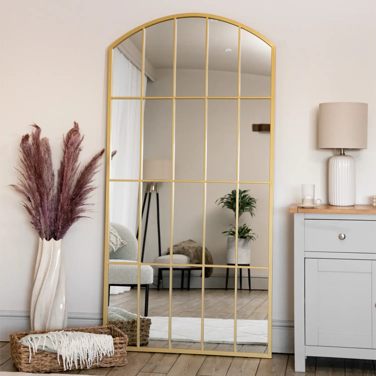 Arched gold-framed mirror with grid pattern dividers.