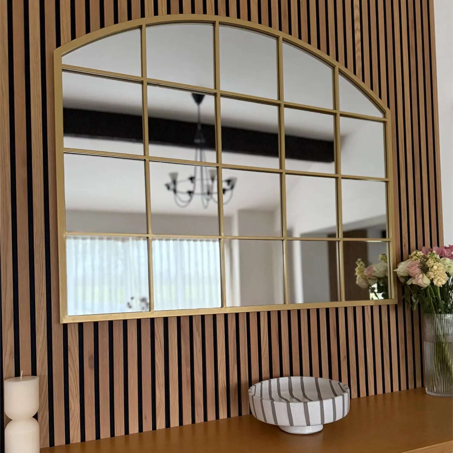 Gold-framed arched mirror with grid pattern dividers.