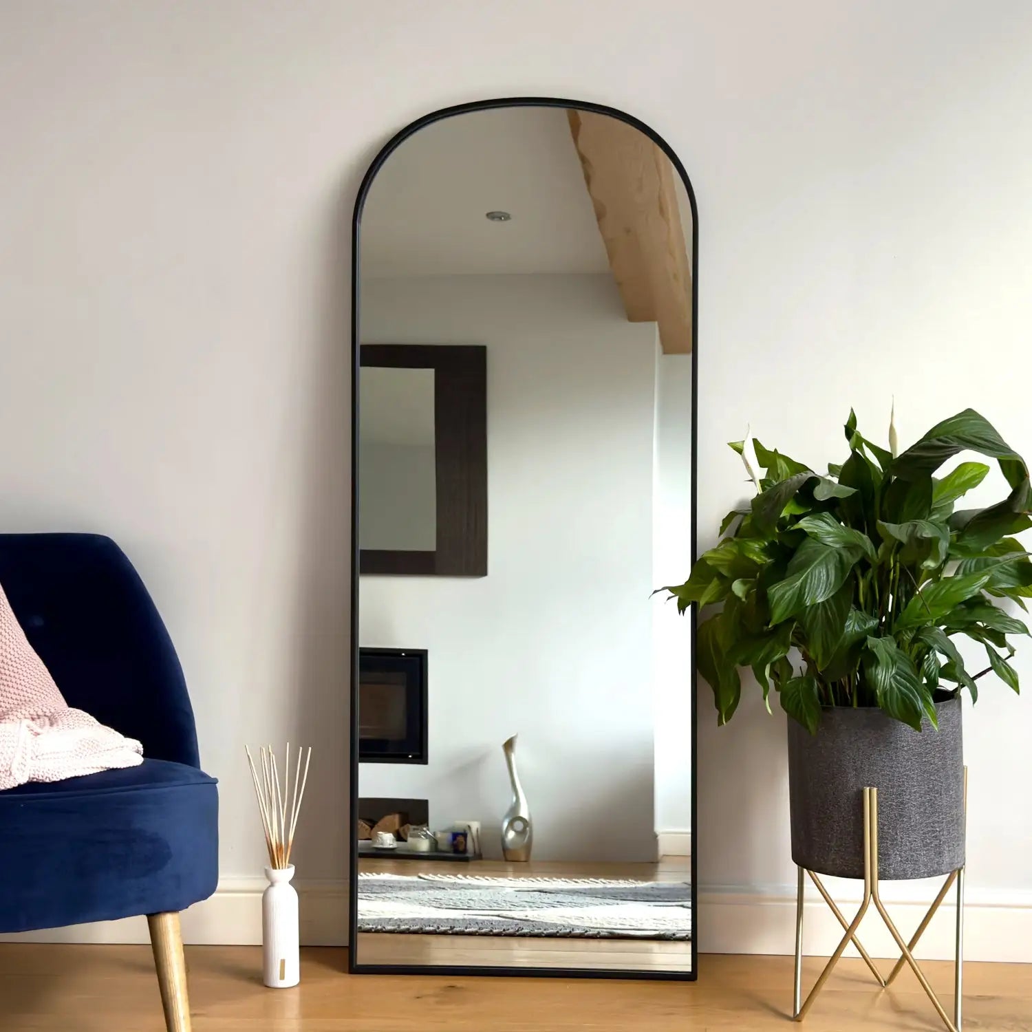 Arched floor mirror with a black metal frame.