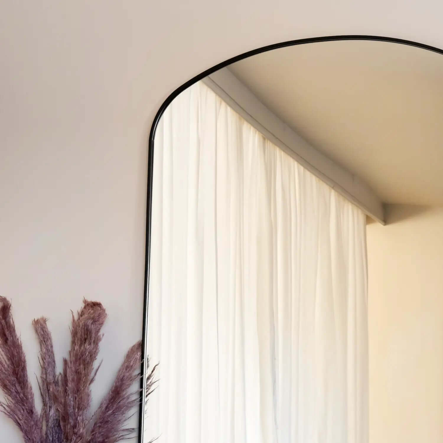 Arched black-framed mirror with a minimalist design.