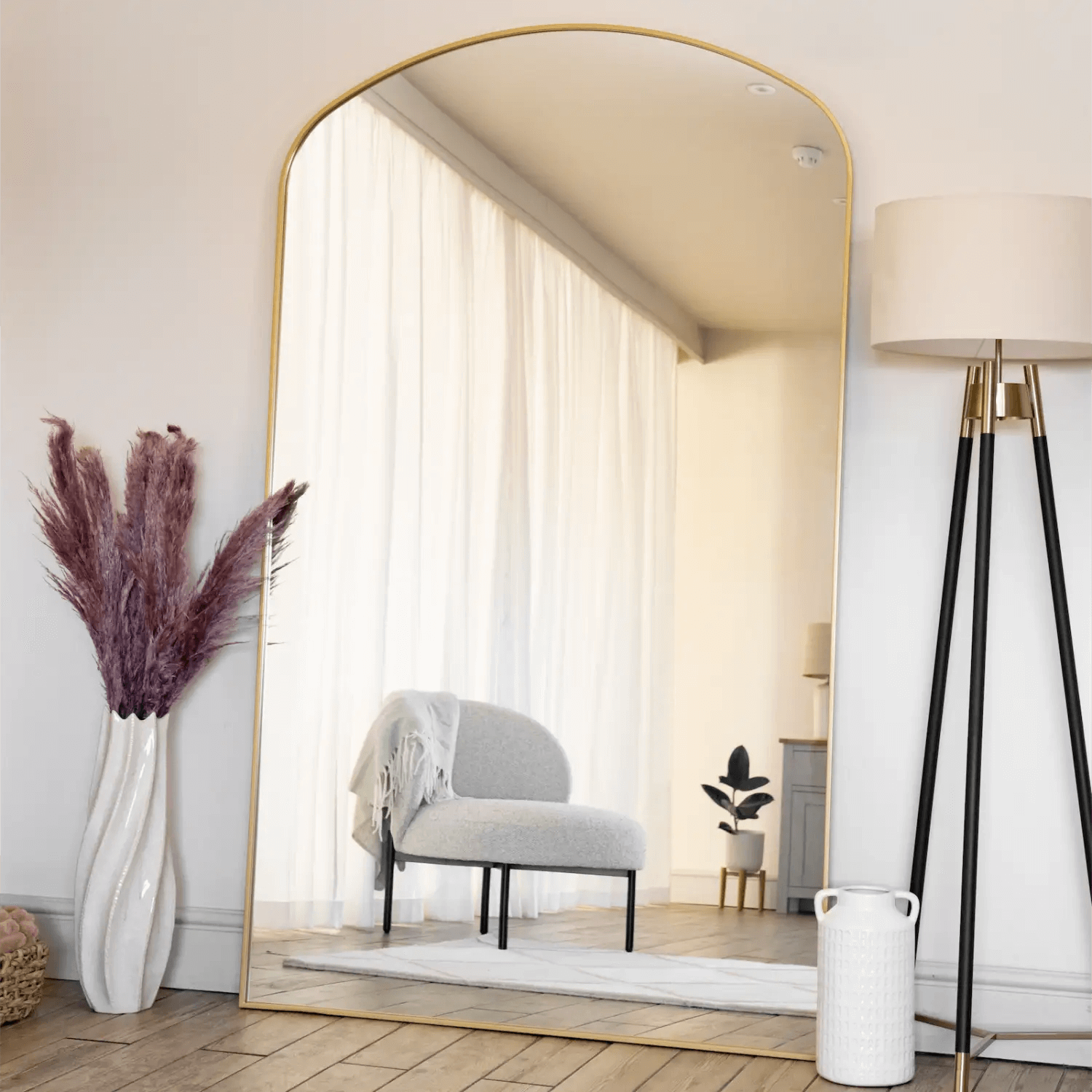 Arched mirror with a thin gold frame.