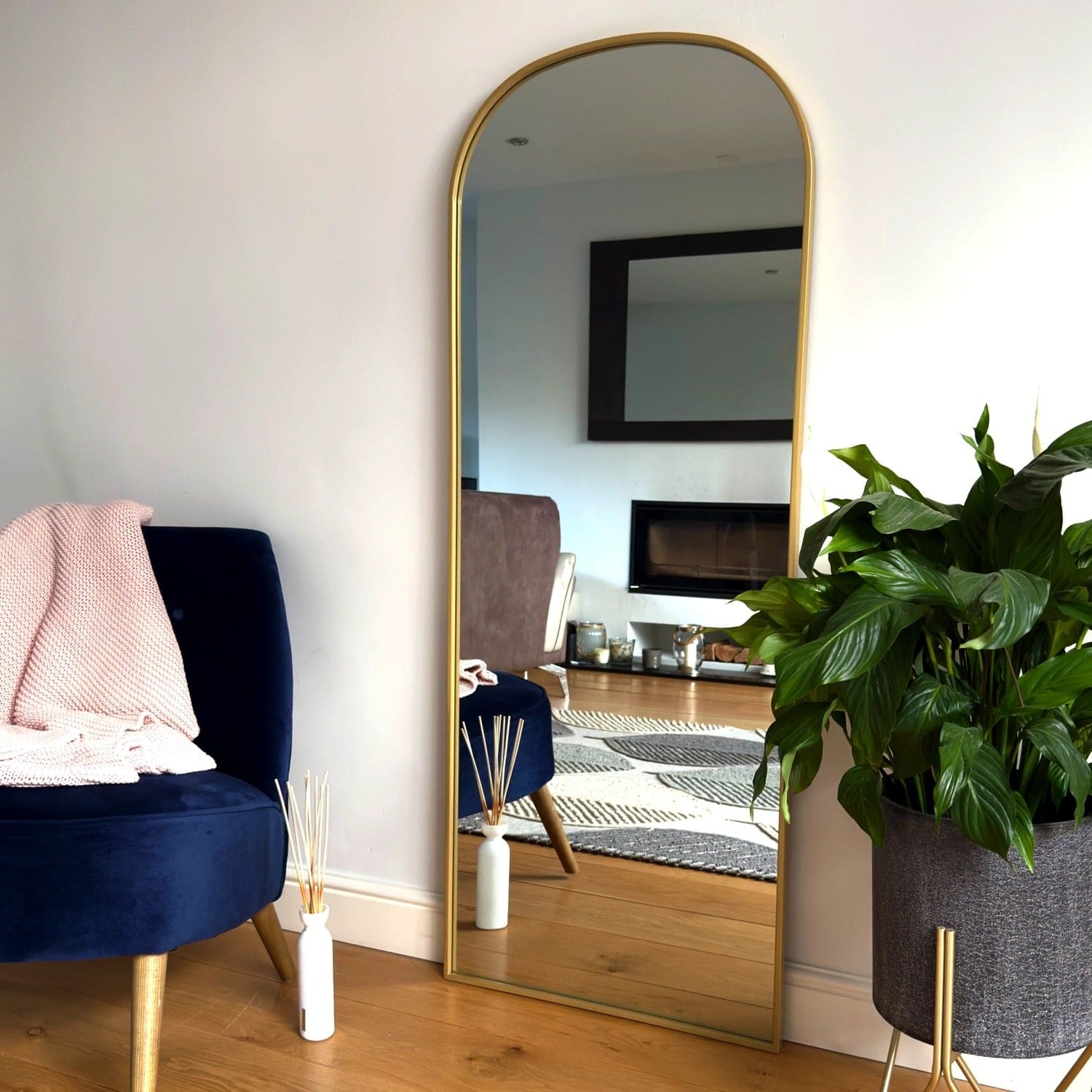 Gold-framed arched mirror.