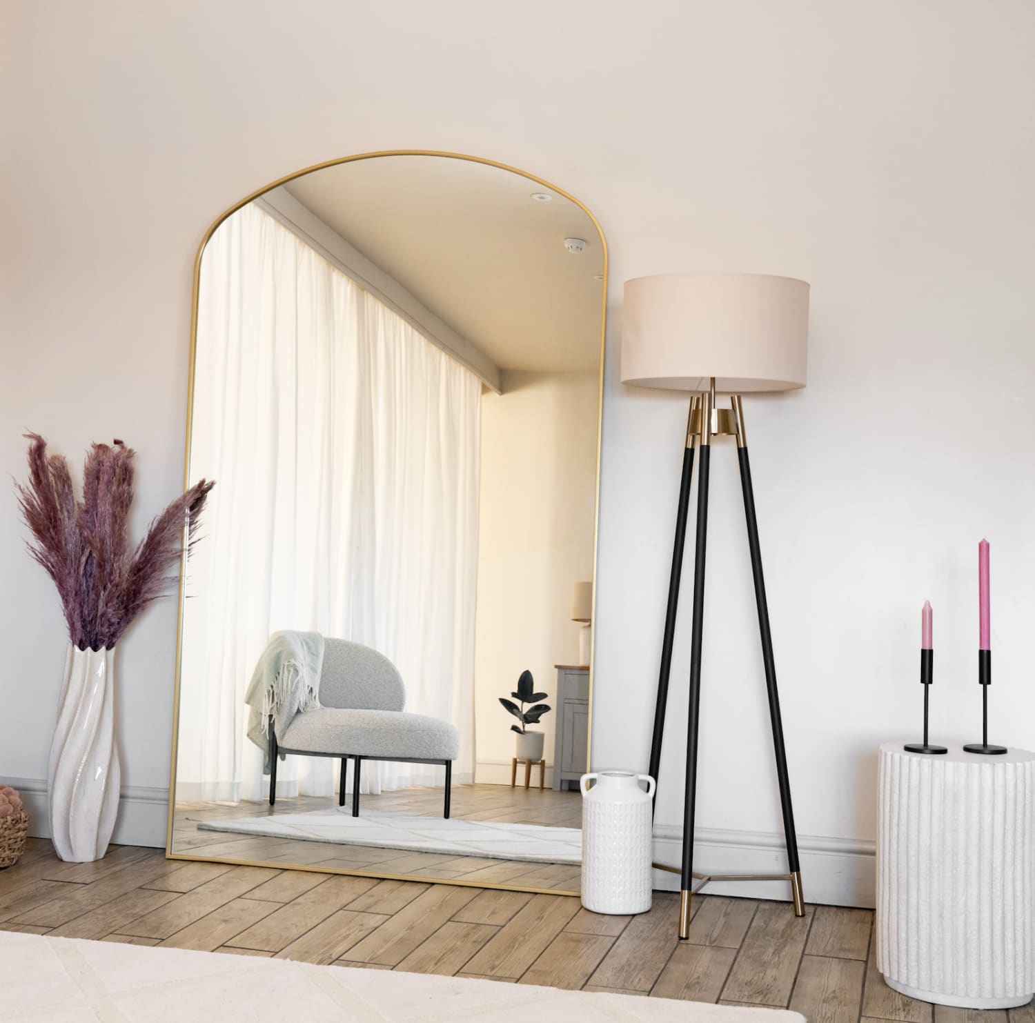 Arched mirror with a thin gold frame.