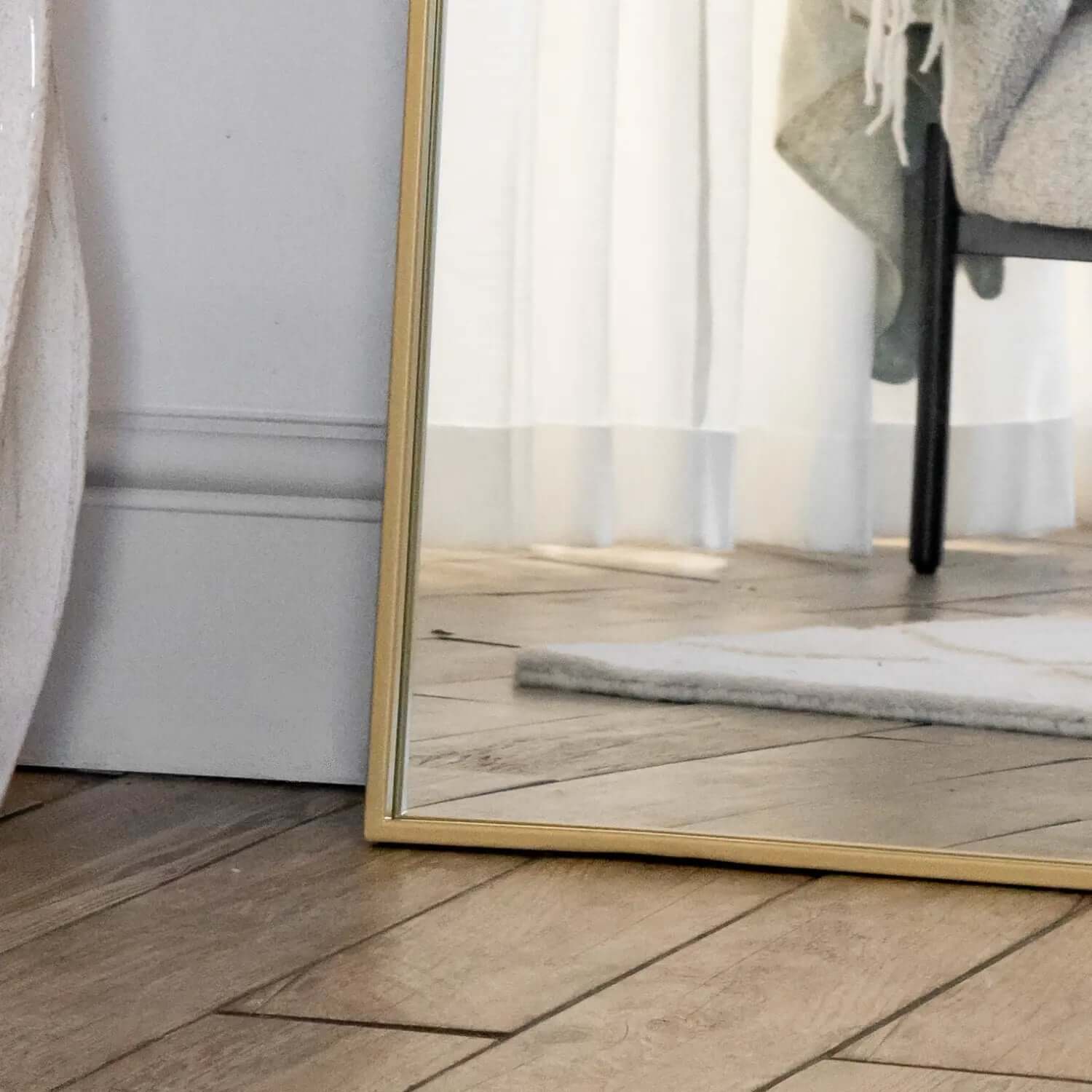 Gold-framed mirror resting on a floor.